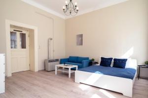 een slaapkamer met een blauw bed en een blauwe stoel bij Blue Ribbon Apartment in Boedapest