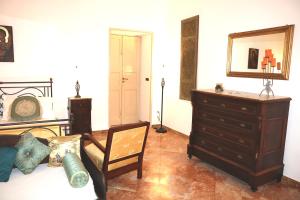 a room with a dresser and a bed and a chair at B&B Il Giardino di Paola in Alliste