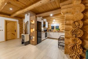 a large kitchen with wooden walls and wooden floors at BRZOZOWY SZELEST in Ustrzyki Dolne