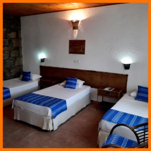 a hotel room with two beds with blue pillows at Pedracin Village in Ribeira Grande