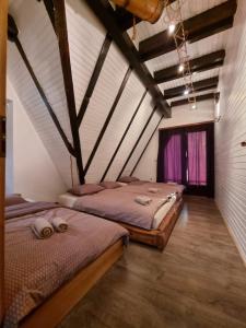 2 Betten in einem Zimmer mit Dachgeschoss in der Unterkunft Vikendica Blidinje Čarobna kuća in Tomislavgrad