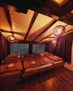 ein Schlafzimmer mit einem großen Bett im Dachgeschoss in der Unterkunft Vikendica Blidinje Čarobna kuća in Tomislavgrad