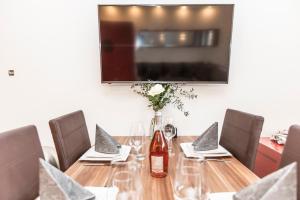 drewniany stół z krzesłami i butelkę wina w obiekcie Smart Resorts Haus Rubin Ferienwohnung 102 w mieście Winterberg