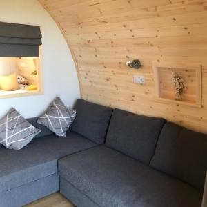 The Ardmore Pod في Trumpan: غرفة معيشة مع أريكة في منزل صغير
