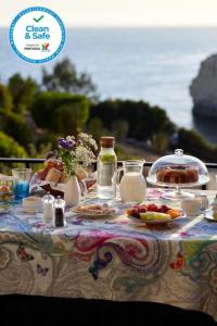 a table with food and drinks on top of it at Os Reais - Apt in front of the beach in Centeanes in Carvoeiro