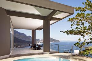 a view of the ocean from a house with a swimming pool at La Suite by Dussol in Rio de Janeiro