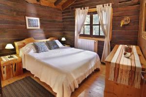 a bedroom with a bed in a wooden room at Tá Péfka - Suites & Cabañas con hidromasaje in La Cumbrecita