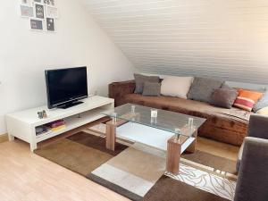 a living room with a couch and a coffee table at FeWo Royal & Goodness Home in Mühlhausen