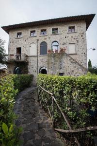 - un grand bâtiment en pierre avec des fenêtres et une passerelle dans l'établissement Sweet home, la casa del piccolo borgo, à Lano