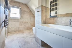 La salle de bains est pourvue d'une baignoire blanche et d'un lavabo. dans l'établissement Smart Resorts Haus Opal Ferienwohnung 406, à Winterberg