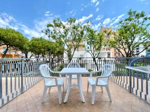 Biały stół i 3 krzesła na patio w obiekcie Hotel Trovatore w mieście Lido di Jesolo