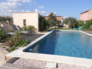 una piscina en un patio con una casa en studio en Saint-André-de-Sangonis