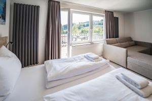 ein Schlafzimmer mit einem Bett, einem Sofa und einem Fenster in der Unterkunft Smart Resorts Haus Diamant Ferienwohnung 708 in Winterberg