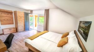 1 dormitorio con 1 cama blanca grande y suelo de madera en Zelena Oaza, en Zgornja Kungota