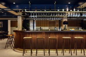 a bar in a restaurant with stools at The Kimpton Shorebreak Fort Lauderdale Beach Resort in Fort Lauderdale