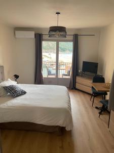 a bedroom with a bed and a view of a balcony at Les résidences du port appartements meublés in Porto Ota