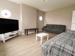 a living room with a couch and a flat screen tv at Kings Walk in Cleveleys