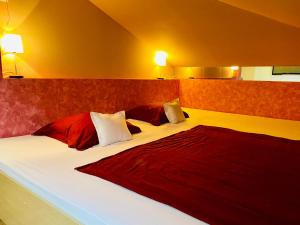 a bedroom with two beds with red and white pillows at Penzion Pohoda in Trutnov