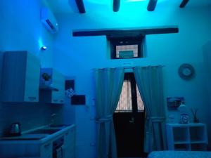- une lumière bleue dans la cuisine avec un évier et une fenêtre dans l'établissement La Castellina, à Naples