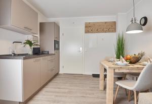 a kitchen and dining room with a wooden table at Smart Resorts Haus Azur Ferienwohnung 808 in Winterberg