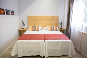 1 dormitorio con 1 cama grande y cabecero de madera en Hotel La Caracola Suances, en Suances