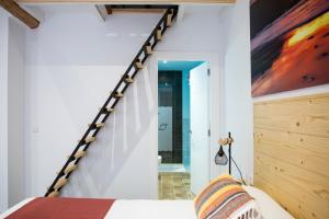 a bedroom with a bed and a staircase in a room at Hotel La Caracola Suances in Suances