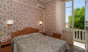 a bedroom with a bed and a window at Hotel Villa Flores in Marina di Pietrasanta