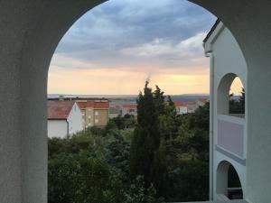 an archway view of a city from a building at Apartments MiaMaja in Novalja