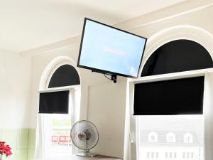 a flat screen tv in a room with two windows at Work & Stay im Herzen von Celle in Celle +12 photos