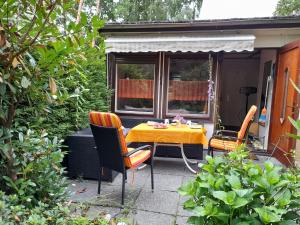 een gele tafel en stoelen op een patio bij Bungalow am Waldbad in Schmannewitz
