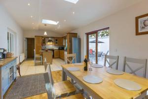 eine Küche und ein Wohnzimmer mit einem Holztisch und einem Esszimmer in der Unterkunft The Villa - On the Waterford Greenway Kilmacthomas in Kilmacthomas