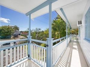Cairns North的住宿－Cairns Sunshine Lodge，带有蓝白色栏杆的房子的门廊