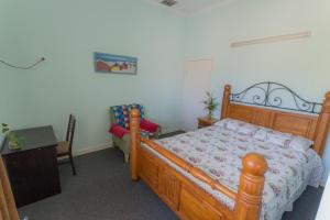 Cairns NorthにあるCairns Sunshine Lodgeのベッドルーム(木製ベッド1台、テーブル付)