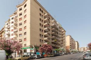 a tall building on a city street with parked cars at Roomy and Bright Apartment with Terrace in Rome