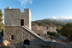 a stone building with mountains in the background at Kamares Villas in Kamáres