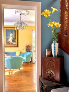 uma sala de estar com paredes azuis e um vaso com flores amarelas em Le 1930, chambres d’hôtes de charme em Cosne Cours sur Loire
