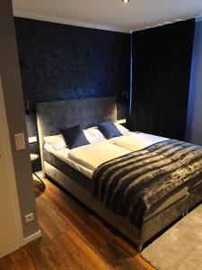 a bedroom with a large bed with a black headboard at Hotel Kornblume in Haundorf