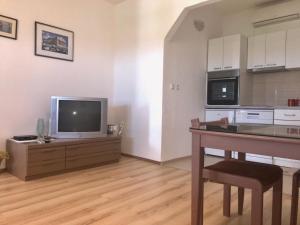 a living room with a table and a tv and a kitchen at Elena in Benkovac