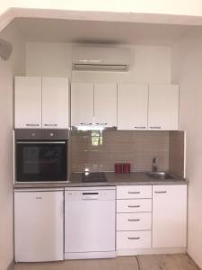 a kitchen with white cabinets and a microwave at Elena in Benkovac