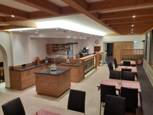 a large kitchen and living room with tables and chairs at Gästehaus Bräuer in Neukirchen am Großvenediger