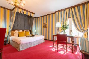 a hotel room with a bed and a desk and a chair at Château De Beauvois - La Maison Younan in Saint-Étienne-de-Chigny