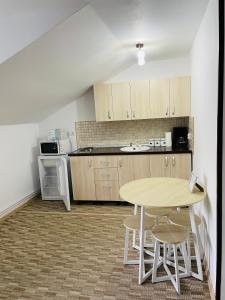 a kitchen with a table and chairs in a room at Garsoniera Studio in Buşteni