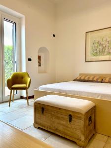 1 dormitorio con 2 camas y silla amarilla en Villa Marta- Puglia Mia apartments, en Impalata