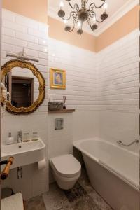 ein Badezimmer mit einer Badewanne, einem WC und einem Waschbecken in der Unterkunft Boutique Apartment Virkas muiža in Kuldīga