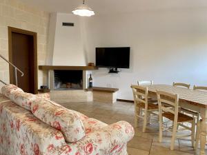 a living room with a couch and a table with a tv at Villa Marta- Puglia Mia apartments in Impalata
