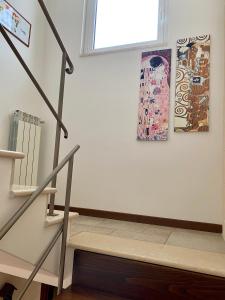 escalera en una habitación con ventana y pinturas en Villa Marta- Puglia Mia apartments, en Impalata