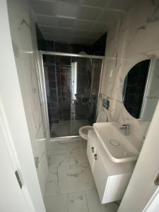 a white bathroom with a sink and a toilet at SORAL APART in Demre