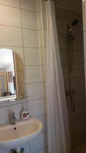 a bathroom with a shower curtain and a sink at Leśniczówka Pokoje Gościnne in Gdynia