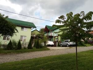 una fila de casas con un coche aparcado en una entrada en Pension Verde en Baia-Sprie