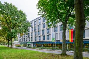 ein großes weißes Gebäude mit bunten Flaggen darauf in der Unterkunft Holiday Inn Express - Goettingen, an IHG Hotel in Göttingen